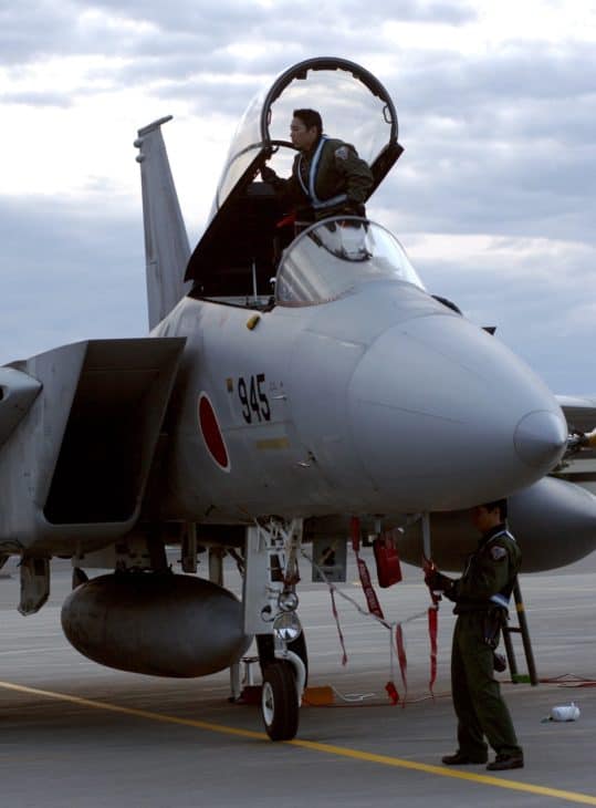 Japanese Air Self Defense Force maintainers work on a F 15J fighter