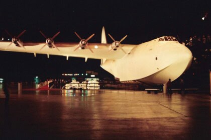 Hughes H-4 Hercules Spruce Goose lit at night, wings and eight propellers spread across the hangar
