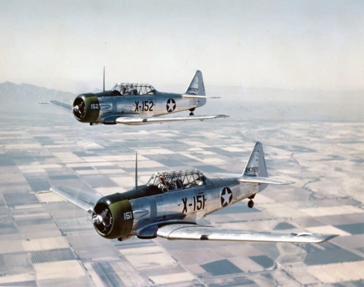 Two U.S. Army Air Forces North American AT 6C NT Texan trainers in flight.