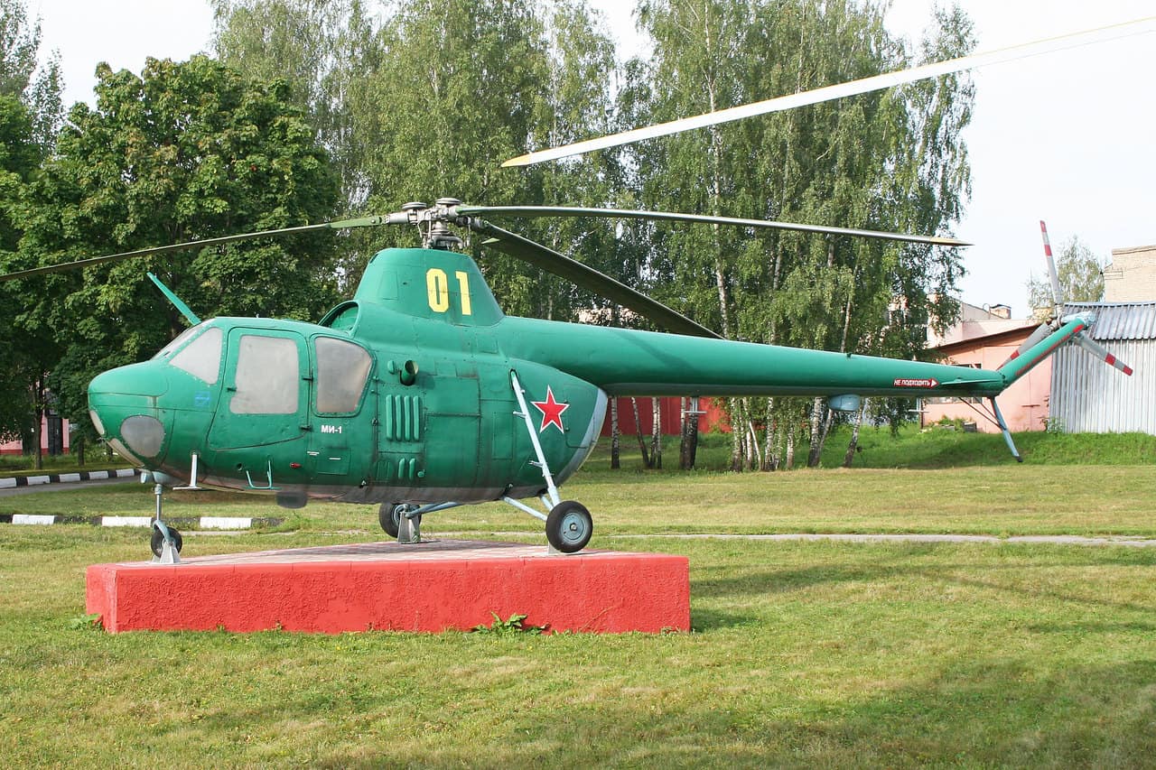 Preserved green Mil Mi-1 helicopter on a red plinth