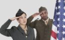 Multi ethnic US military officers saluting American flag