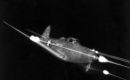 Bell P 39 Airacobra in flight firing all weapons at night.