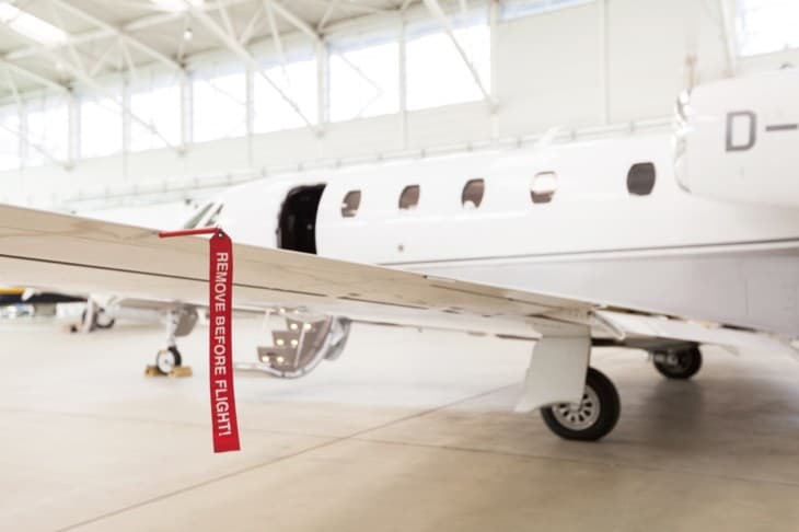 Airplane in Hangar with remove before flight Labels