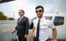Business man and private helicopter pilot in front of helicopter