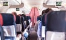 Interior of commercial airplane with passengers on seats during flight