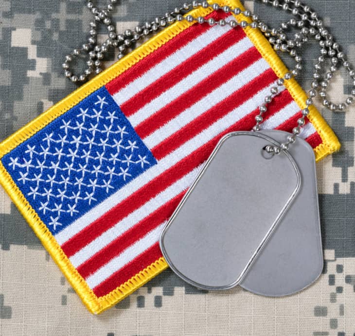 American flag with dog tags on camouflage