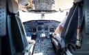 Rear view of pilot and copilot flying comercial airplane
