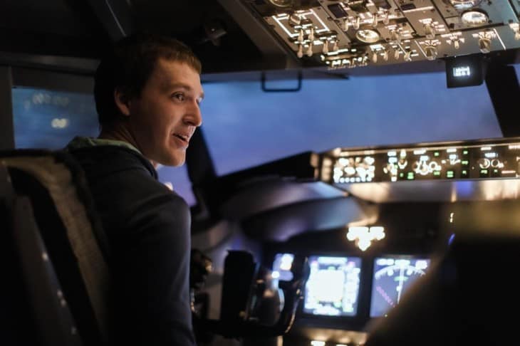 Young man piloting a plane in flight simulator