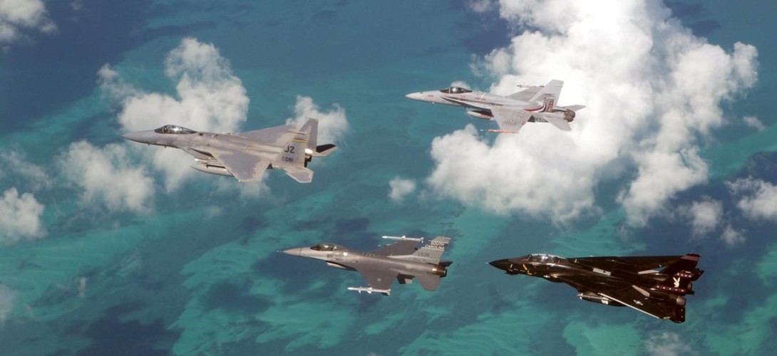 An Air Force F 15 Eagle and F 16 Falcon fly in formation with a Navy F 14 Tomcat and FA 18 Hornet over the Atlantic Ocean during exercise Cope Snapper 2002 at Naval Air Station NAS Key West.