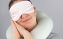 woman with travel pillow and sleeping mask