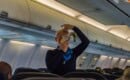 air hostess shows how to use an oxygen mask on board