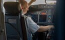 focused professional pilot sitting in an airplane cabin ready for takeoff