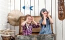two little kids in pilot hats making glasses with hands