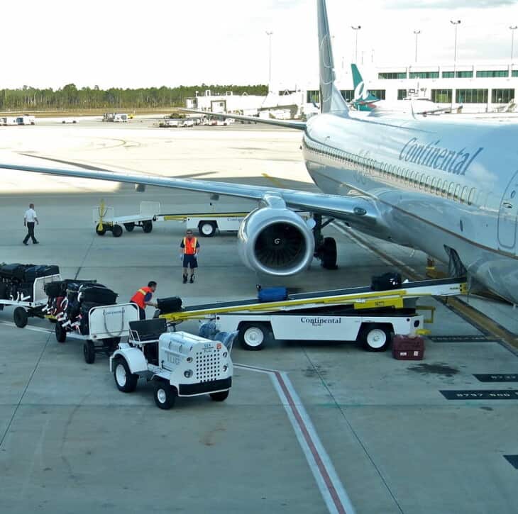 baggage handlers loading airplane crop