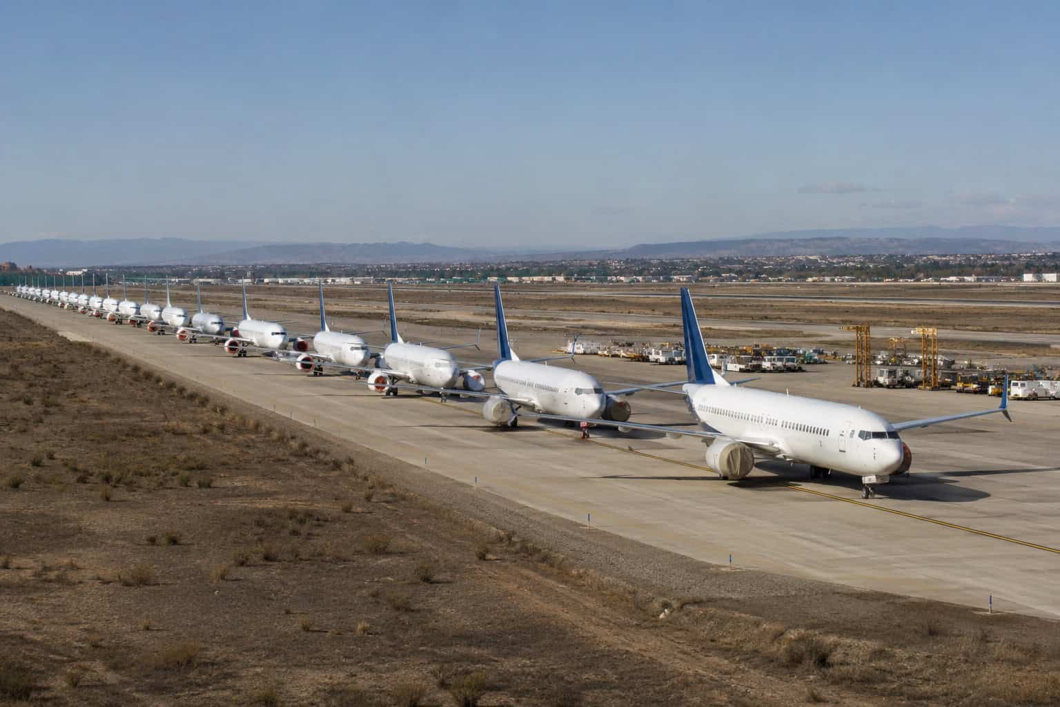 A row of Boeing 737 MAX aircraft parked in a remote storage area