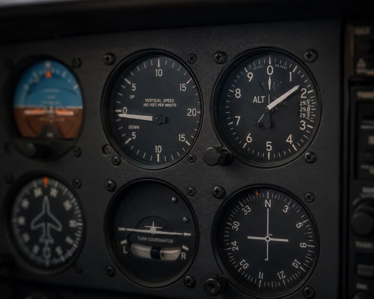Pilot's view of the vertical speed indicator and altimeter on an instrument panel during a descent, VSI needle pointing below zero