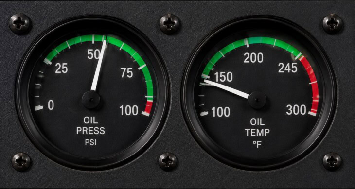 Oil pressure and oil temperature gauges side by side on a light aircraft instrument panel, needles sitting in the green normal operating arcs