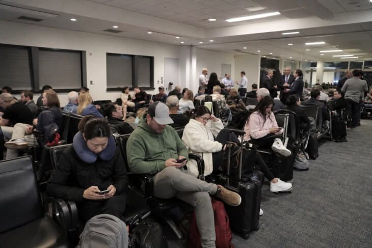 Passengers waiting in a small airport terminal after an unplanned flight diversion