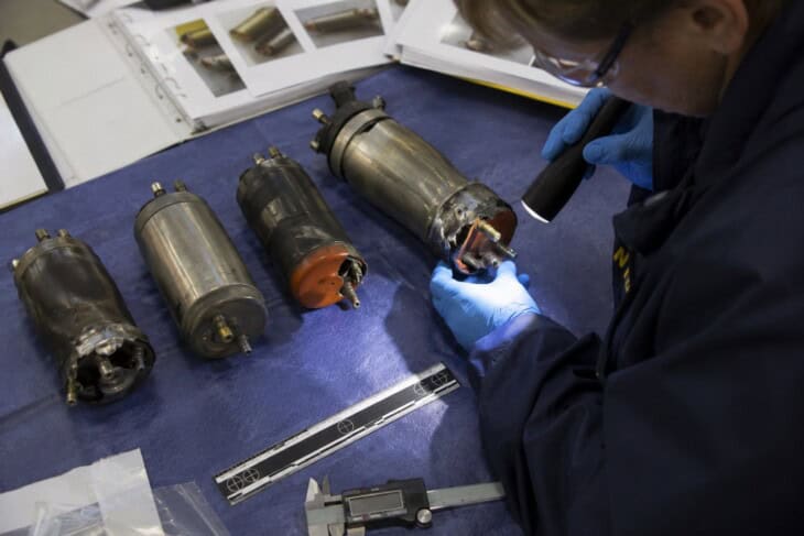 NTSB investigator examining chemical oxygen generators recovered from the ValuJet Flight 592 investigation