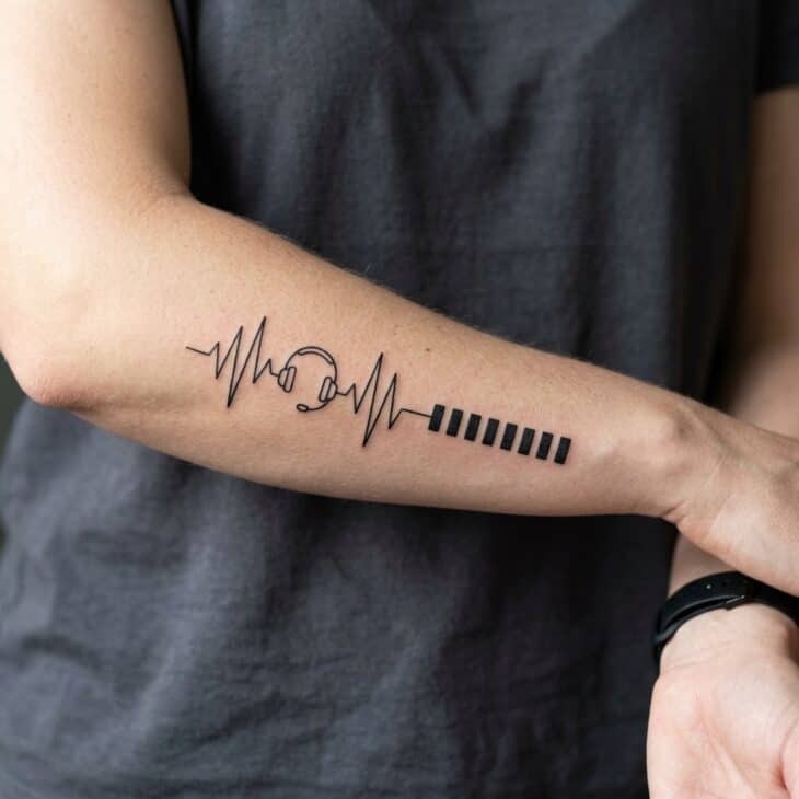 Small aviation phrase style tattoo on an adult inner forearm with radio-wave lines and a tiny headset icon