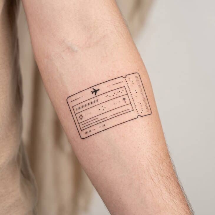 Fine-line boarding pass inspired tattoo on an adult forearm with abstract unreadable details and tiny airplane icon