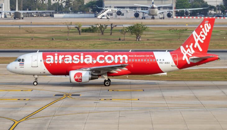 Thai AirAsia Airbus A320-216 HS-ABU in red livery with the airasia.com logo on its fuselage