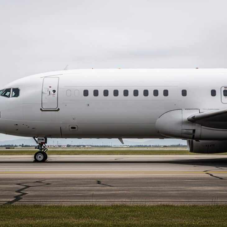 Commercial aircraft fuselage in profile on a taxiway under soft overcast light with detail visible across the entire surface