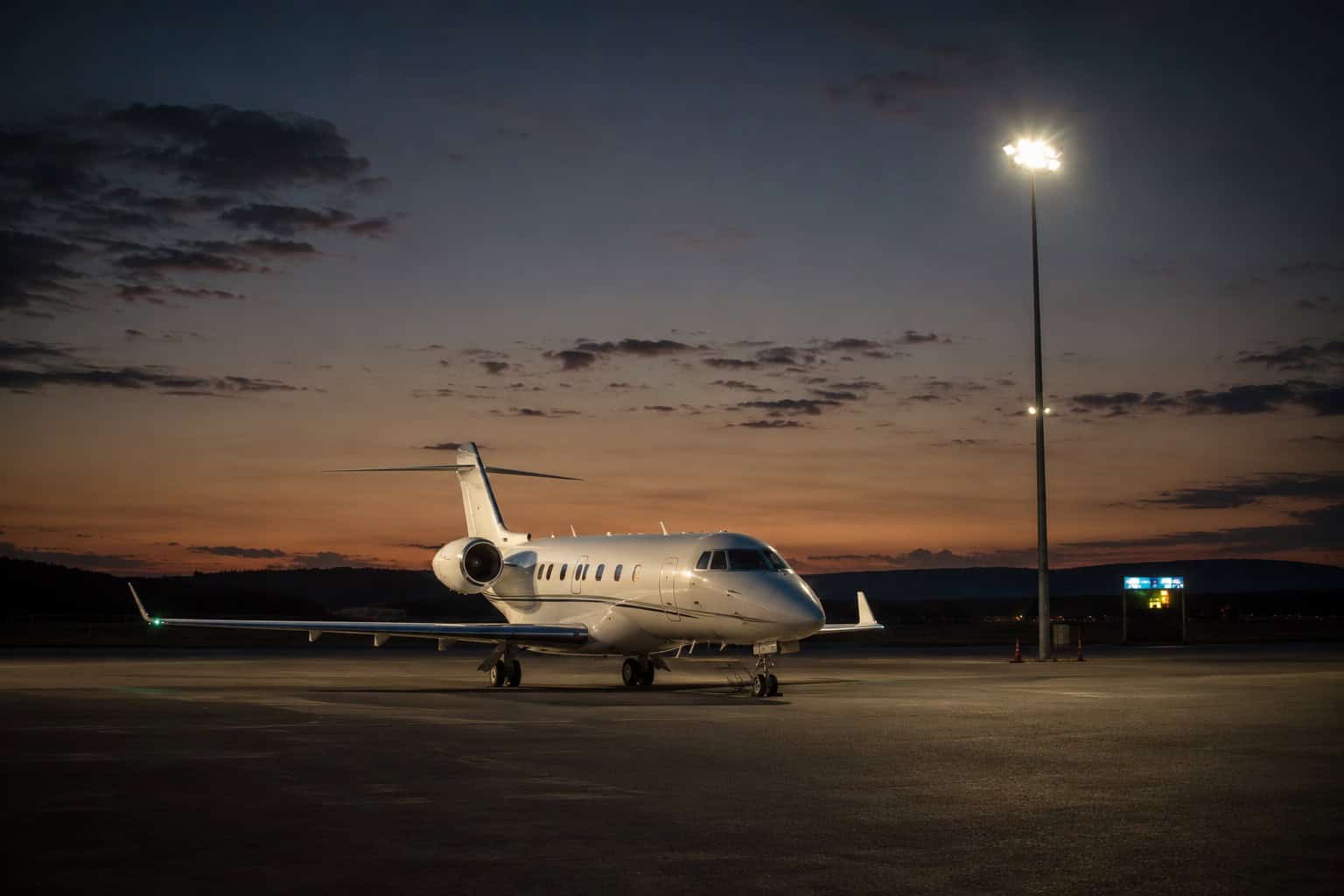 private jet parked alone on a remote general aviation ramp at dusk