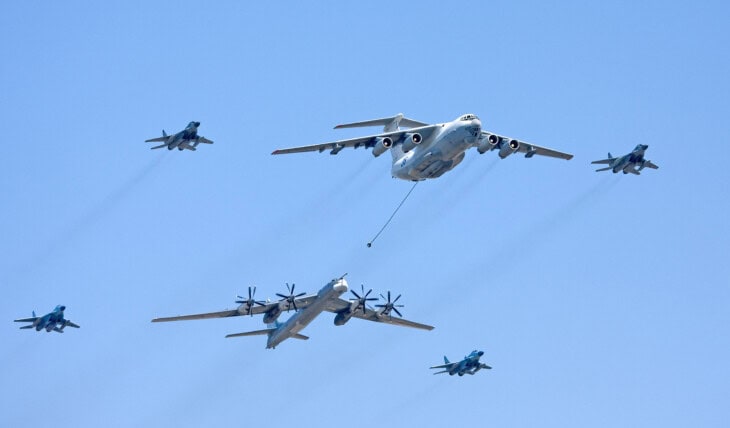 Ilyushin Il-78 tanker trailing hoses to a Tu-95 bomber and escorting fighters in flight