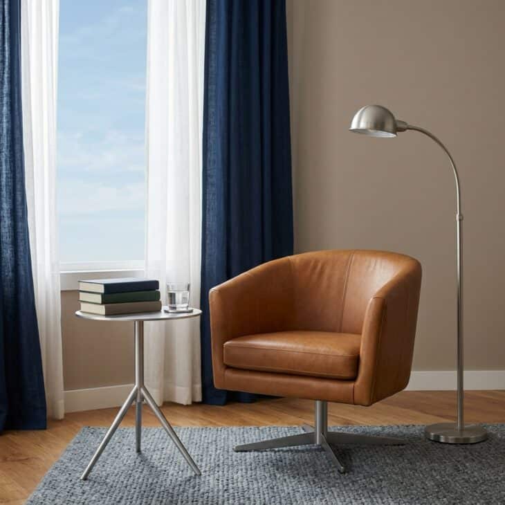 Leather, brushed metal, and focused light create a calm airport-lounge reading corner.