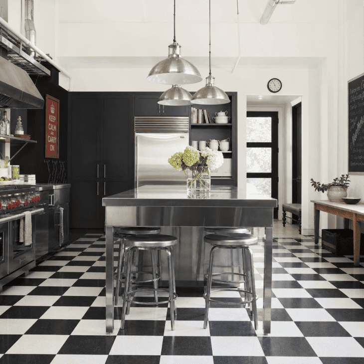 Checkerboard hangar-style flooring anchors the kitchen in bold black and white.