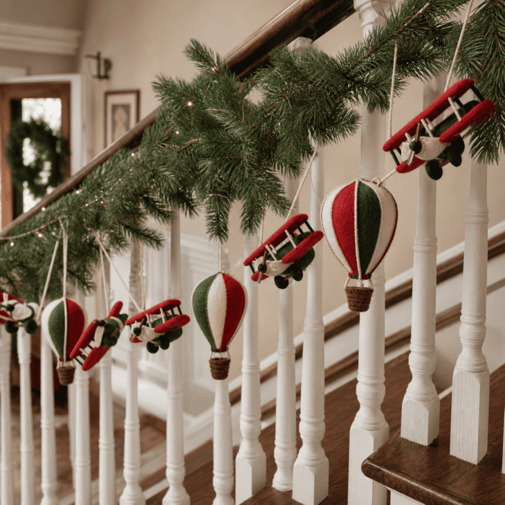 Felt hot air balloons and biplanes alternate along a pine garland on the staircase.