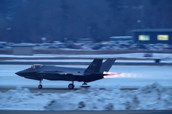 Japan Air Self-Defense Force F-35A on a snow-lined runway at Misawa Air Base with its afterburner lit