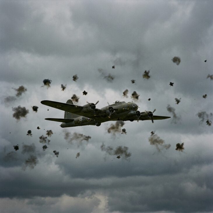 WWII heavy bomber flying through a sky filled with anti-aircraft flak bursts