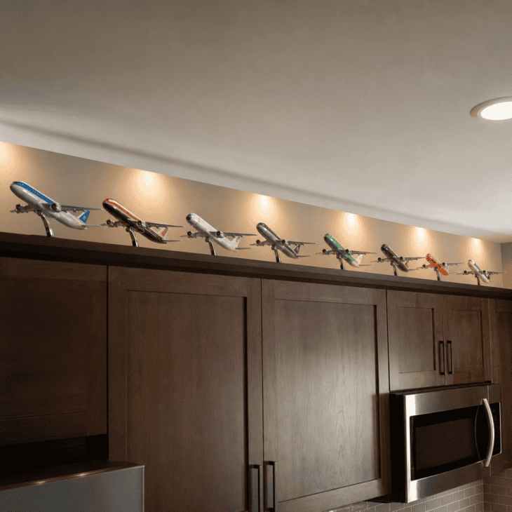 A row of model airplanes lines the shelf above the kitchen cabinets.