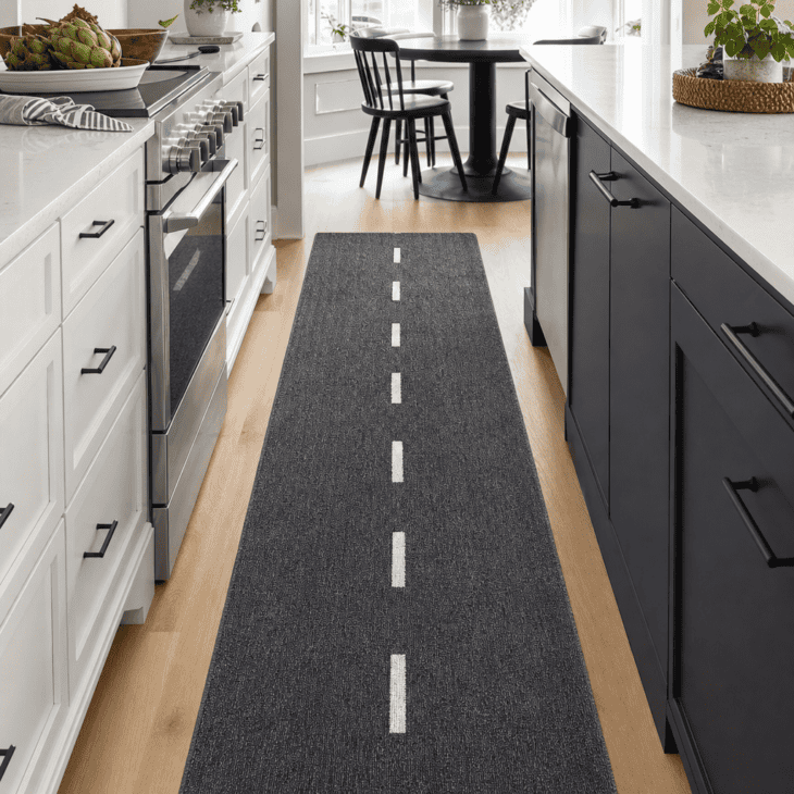 A runway-stripe runner leads the eye down the length of the galley kitchen.