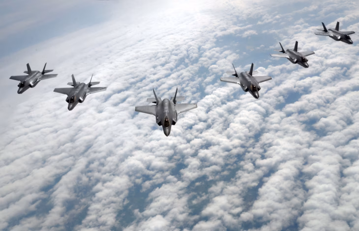 Formation of US Air Force F-35A Lightning II fighters flying above a layer of cloud