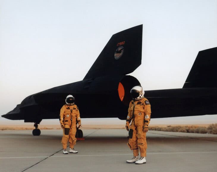 The crew of a NASA Lockheed SR 71 Blackbird standing by the aircraft in their pressurized flight suits, 1991