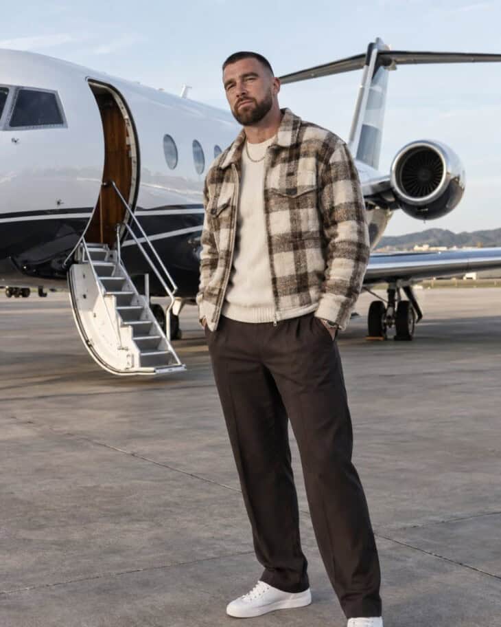 Travis Kelce in front of a private jet vertical