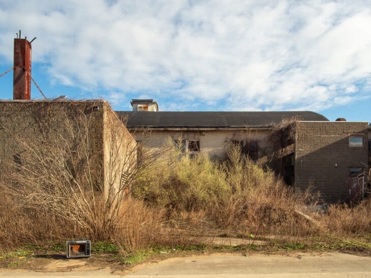 A roofless abandoned building overgrown with brush at Floyd Bennett Field