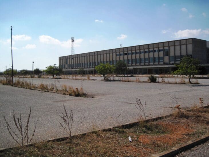 Nicosia International Airport's abandoned terminal behind a weed-covered parking lot