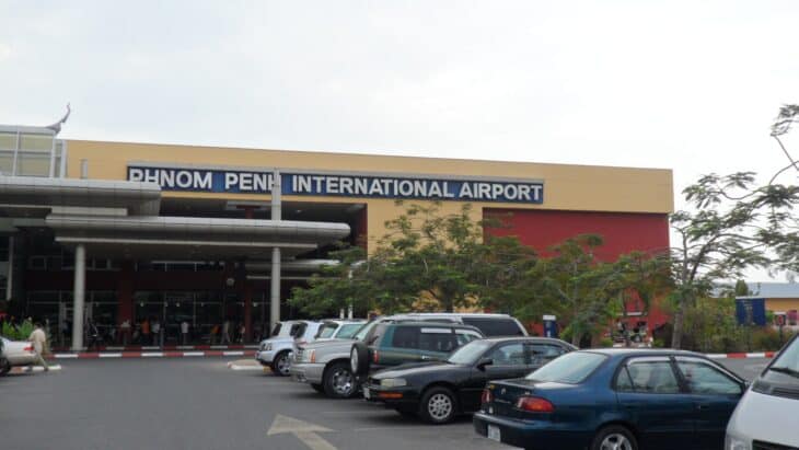 Front of the Phnom Penh International Airport terminal building with cars parked outside