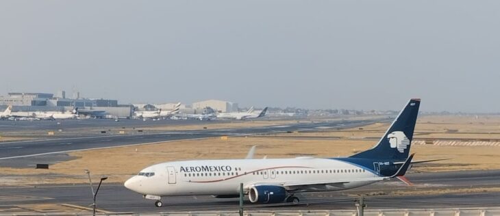 Aeromexico Boeing 737-800 XA-ADT taxiing at Mexico City International Airport with terminals and parked jets in the background
