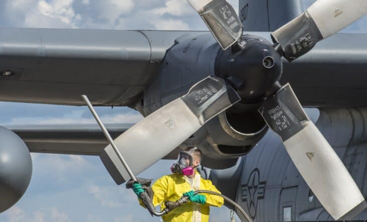 A 910th Maintenance Squadron technician transfers insecticide from a barrel into the spray tank of a C-130 Hercules