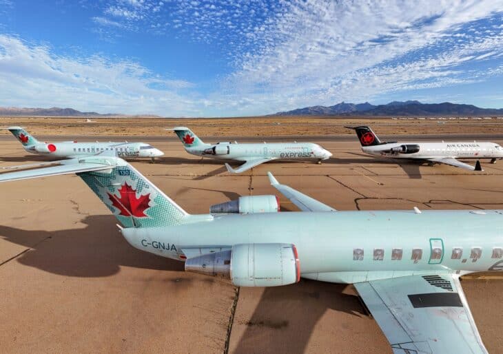 Retired Air Canada Express CRJ-200 regional jets parked on the desert ramp at Kingman Airport, with mountains behind