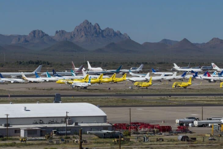 Rows of stored airliners at Pinal Airpark with desert mountains behind them