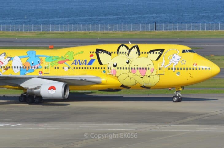 Nose of ANA Boeing 747-400D JA8957 in the yellow Pikachu Jumbo livery, with Pichu and Mew painted beside the cockpit windows.