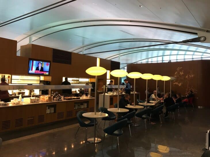 Diners under yellow pendant lamps in Air Canada's international Maple Leaf Lounge at Toronto Pearson