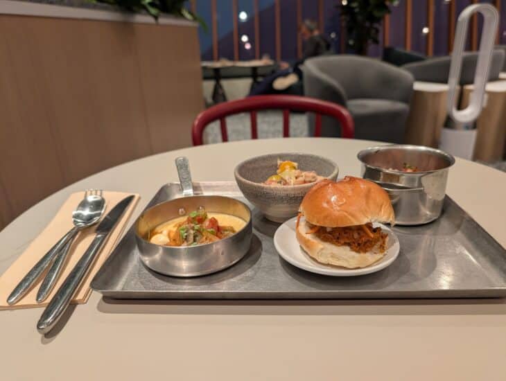 A tray with a burger, a bowl and sides on a table in the Capital One Lounge at Washington Dulles