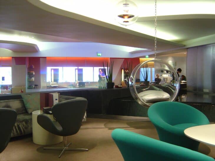 Green swivel chairs and a hanging bubble chair in the Virgin Atlantic Clubhouse at London Heathrow Terminal 3